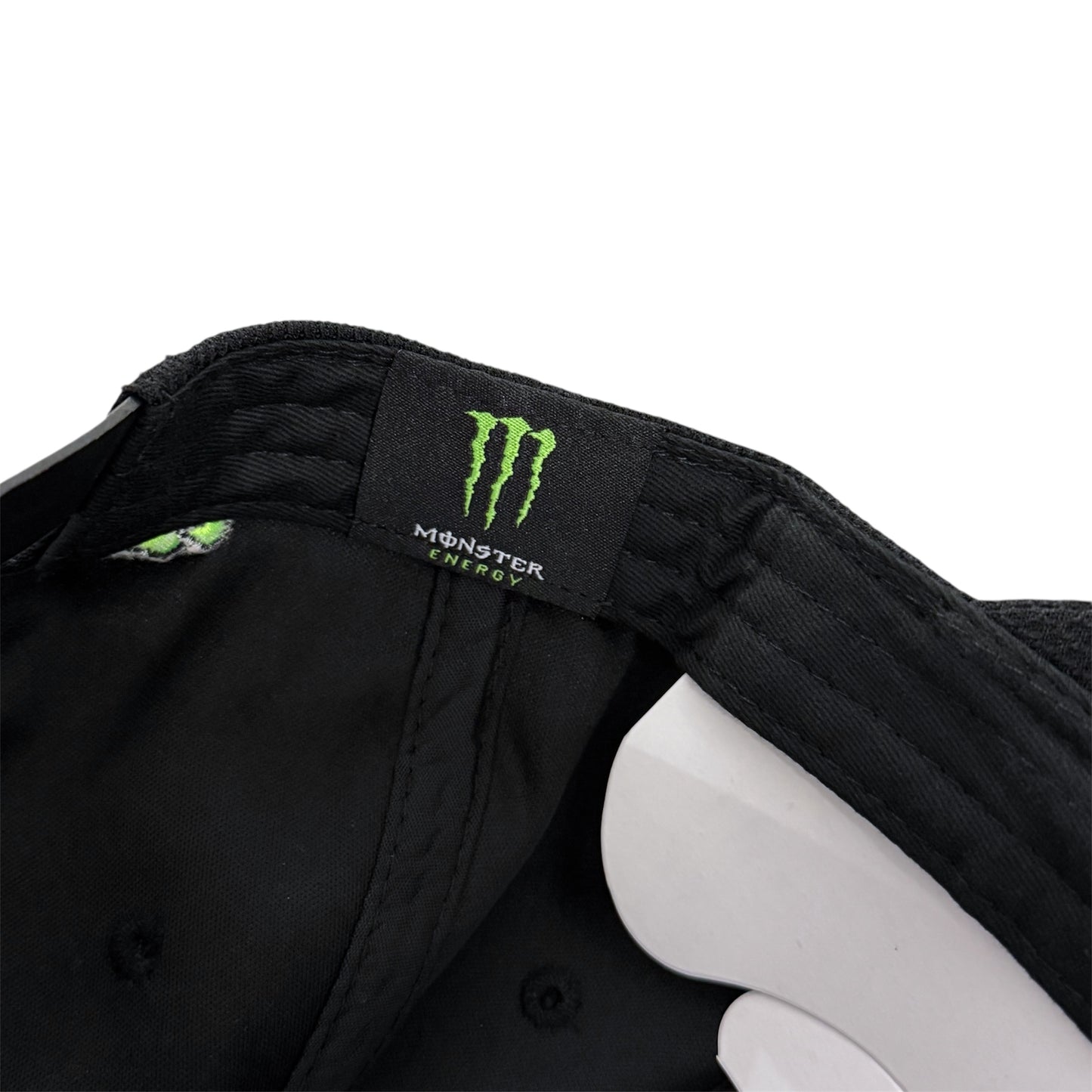 Close-up of a a Monster Energy logo inside a hat on a white background