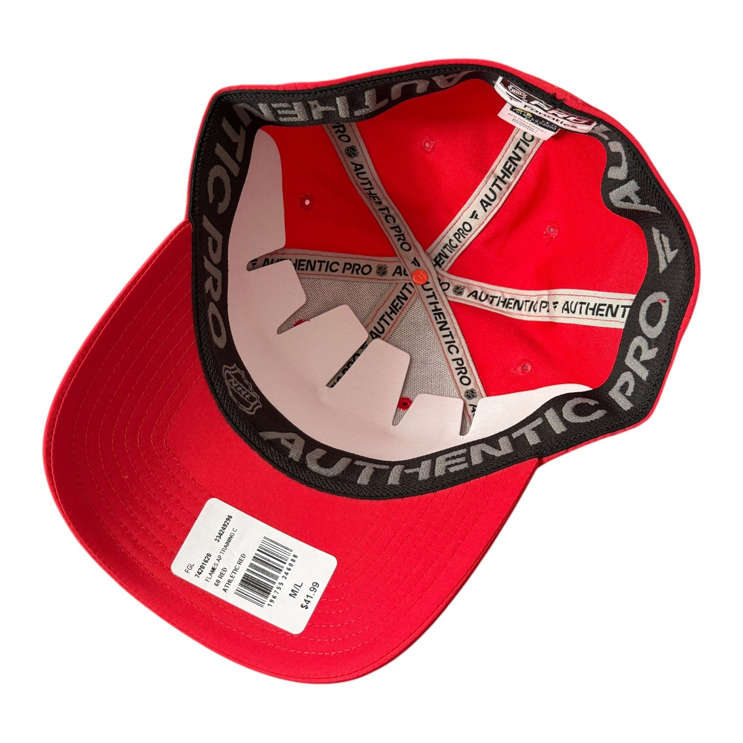A red baseball cap shown from the inside, featuring a black underband with white 'AUTHENTIC PRO' text and white elastic straps. A white price tag is attached to the brim.
