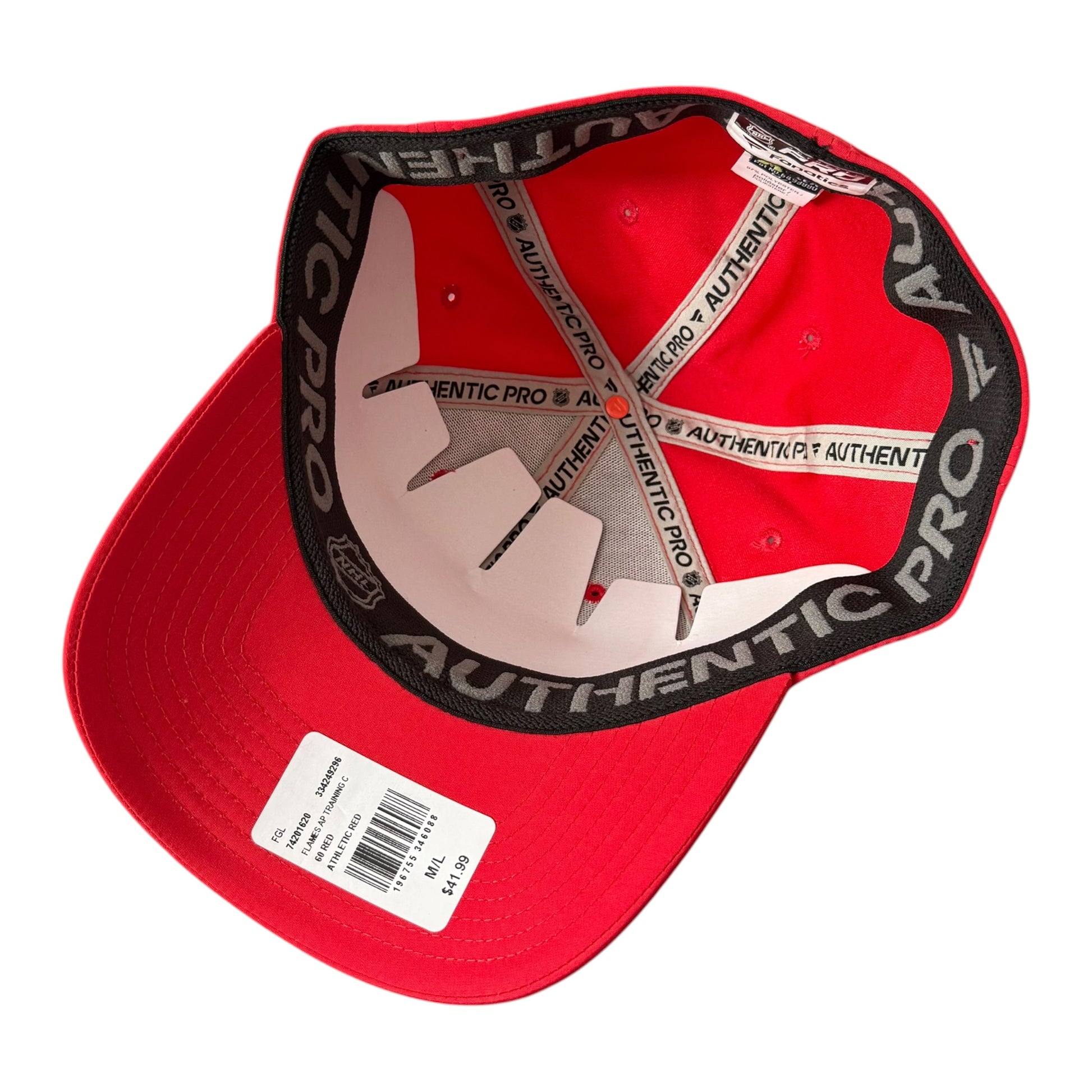 A red baseball cap shown from the inside, featuring a black underband with white 'AUTHENTIC PRO' text and white elastic straps. A white price tag is attached to the brim.