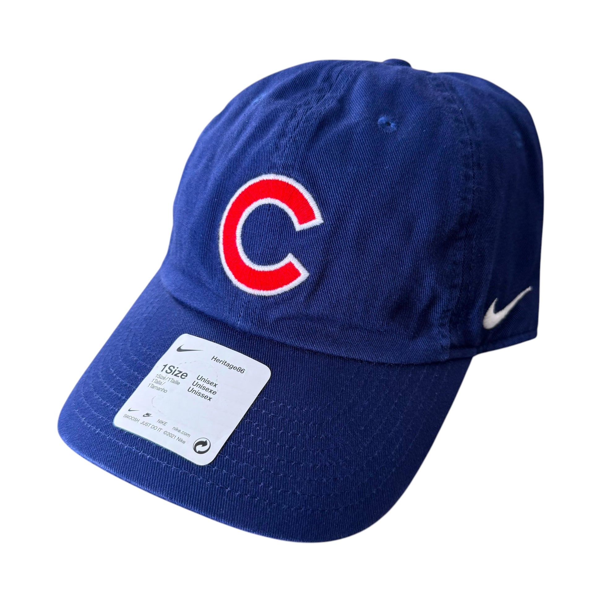 A royal blue Nike baseball cap featuring the Chicago Cubs 'C' logo on the front and a white Nike swoosh on the side. A white size tag is attached to the brim.