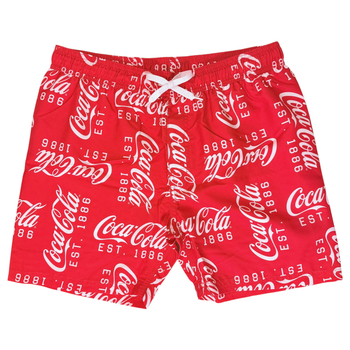 Red Coca-Cola branded swim trunks with an allover white script logo print and a white drawstring at the elastic waistband, shown against a plain white background.