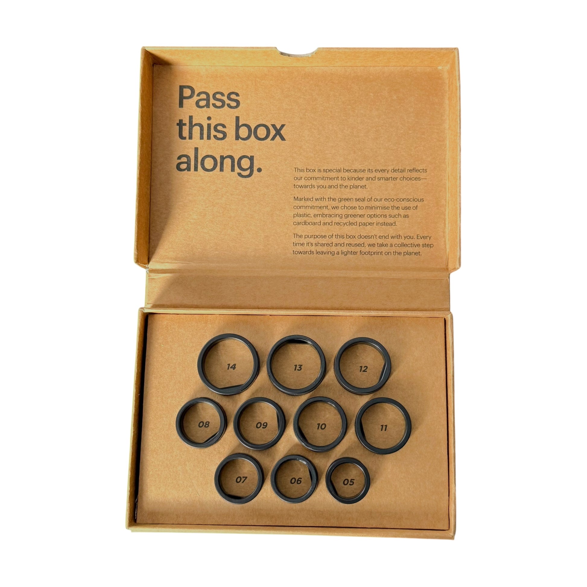 A Diesel x Ultrahuman Air Smart Ring Sizing Kit containing ten small circular numbered rings, with printed text on the inside lid reading 'Pass this box along.'.