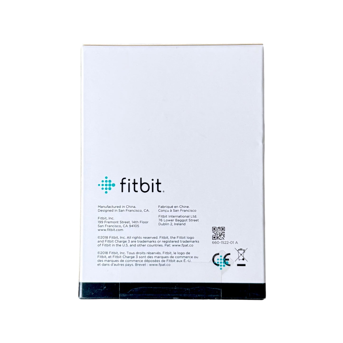 The back of a box showing the fitbit logo, manufacturing details, and a QR code on a white background.