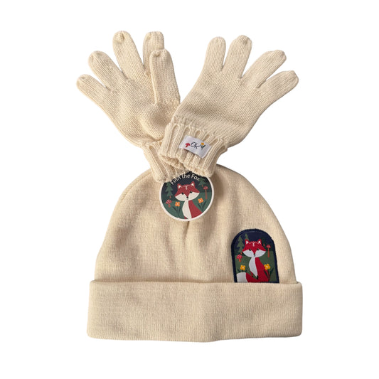 A FlapJackKids cream-colored knit kids beanie and matching knit gloves set, featuring a circular 'Finn the Fox' tag and a matching embroidered patch on the cuff, set against a plain white background.