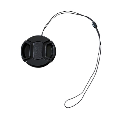 Black camera lens cap with a string on a white background