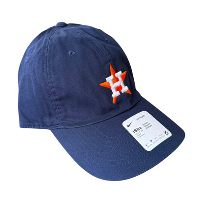 A navy blue baseball cap featuring an embroidered Houston Astros logo on the front and a white size sticker on the brim, set against a plain white background.