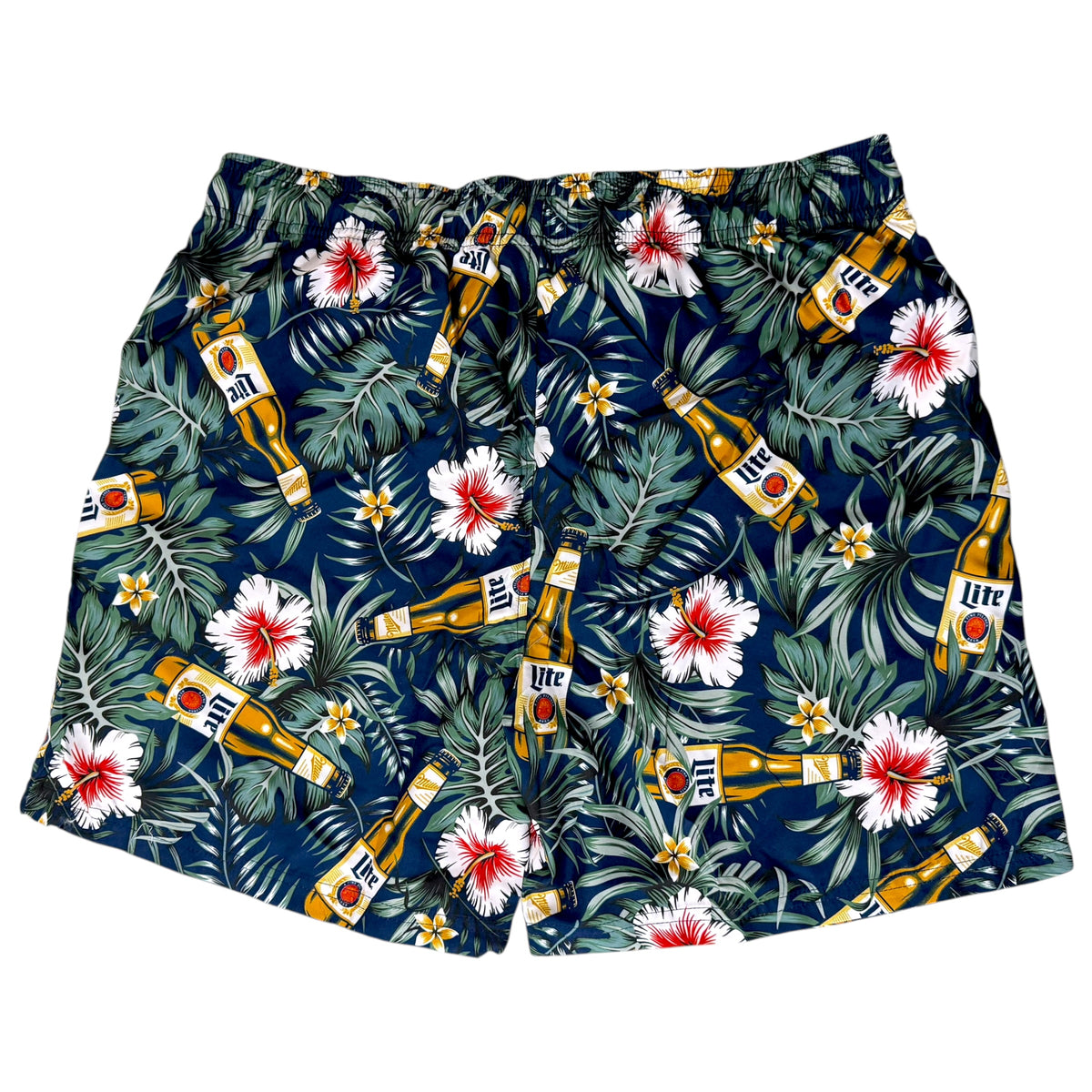 A pair of men's swim trunks featuring a dark navy blue tropical print with green palm leaves, white hibiscus flowers with red centers, and multiple Miller High Life beer bottles scattered throughout the pattern.