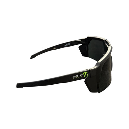 Black Monster Energy wrap-around sunglasses with dark lenses and a small green logo accent on the temple, shown against a plain white background.