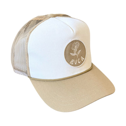 A beige and white trucker hat with a circular tan patch on the front featuring a rose design and the text 'RVCA'.