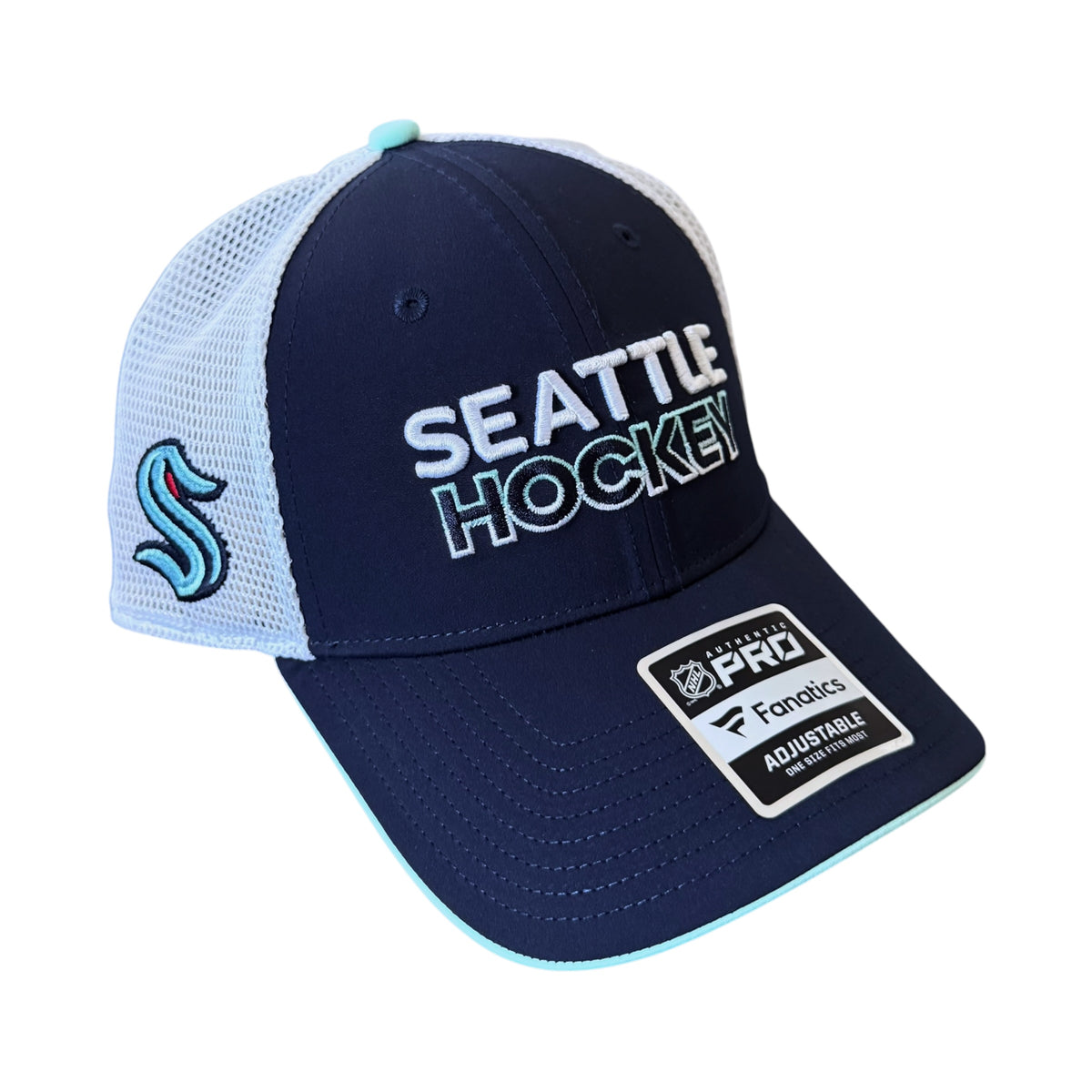 A Seattle Hockey themed trucker hat featuring a navy blue front panel with white and light blue text, a light blue mesh back, a light blue embroidered Seattle Kraken logo on the side, and a Pro Factory adjustable strap patch on the brim.