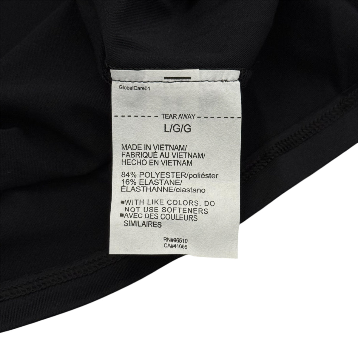 Fabrication label on a black garment with text and material details.