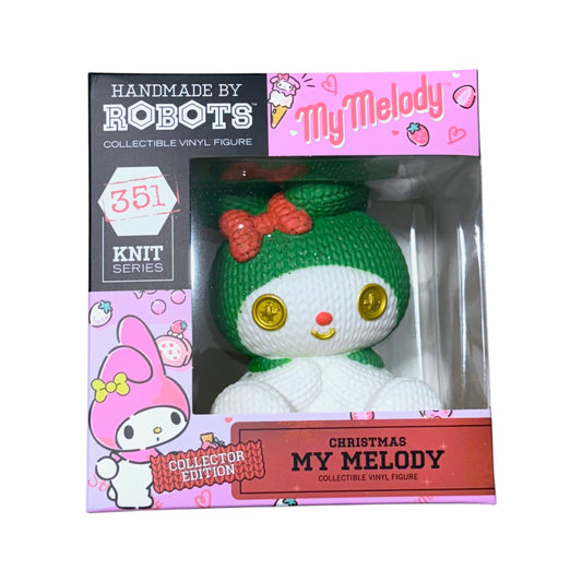 Front of Handmade by Robots Christmas My Melody number 351 vinyl figure in its pink window box, with green hood, red bow and gold button-style eyes.