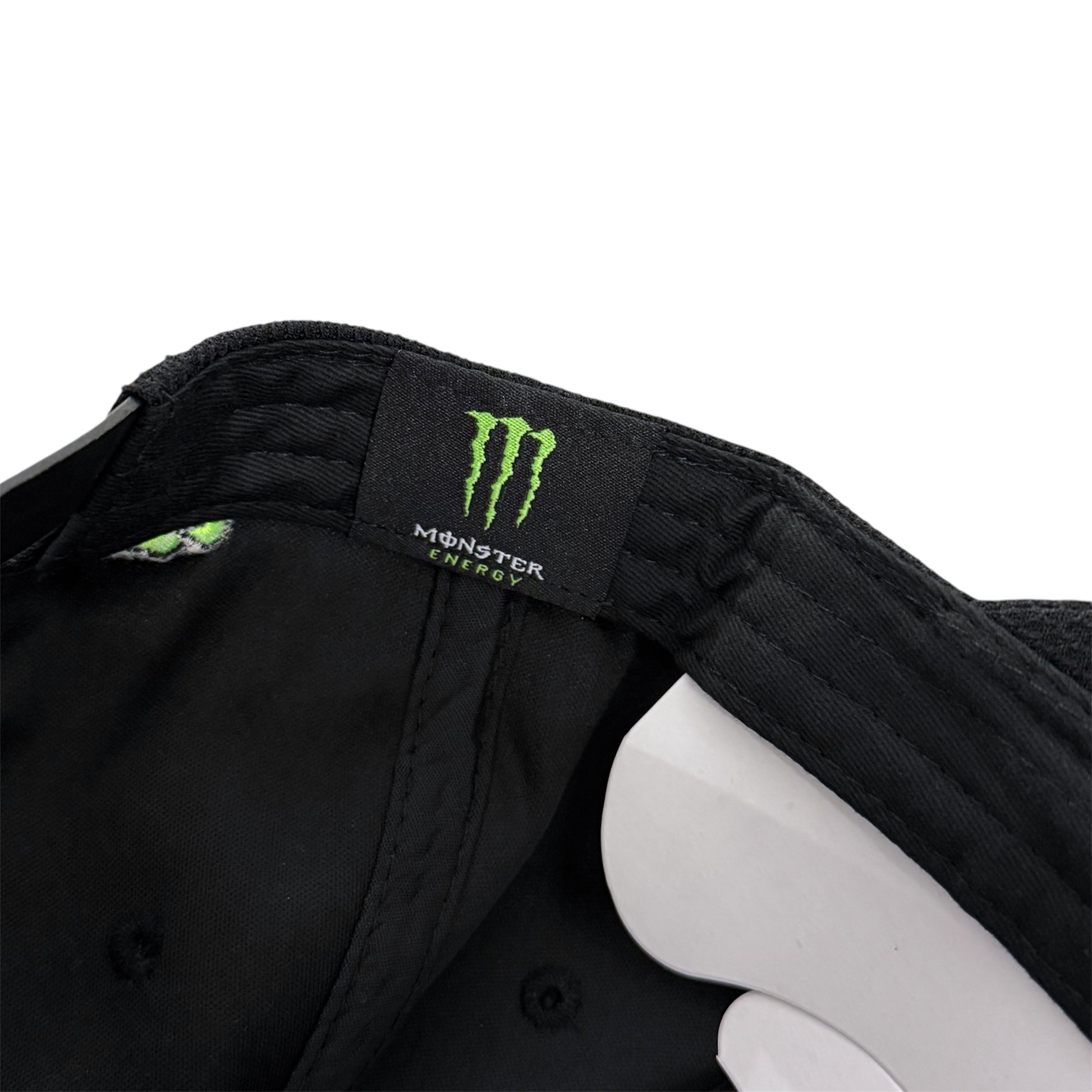 Close-up of a a Monster Energy logo inside a hat on a white background